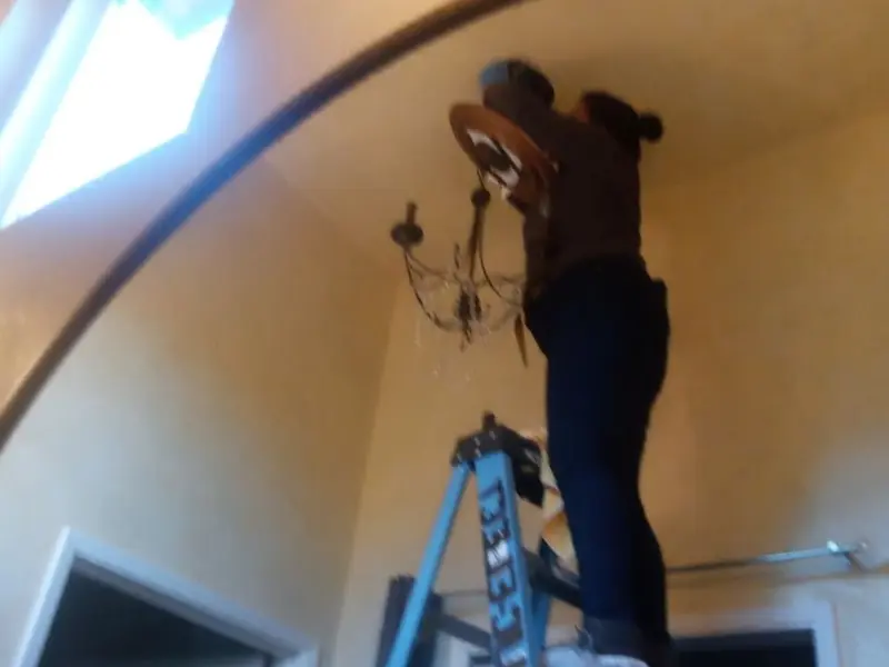 Electrician installing a chandelier in a Redmond residence